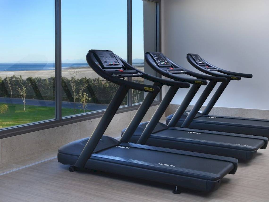 Fitnessstudio im Steigenberger Resort Ras Soma mit Blick auf das Meer und drei schwarzen Laufbändern