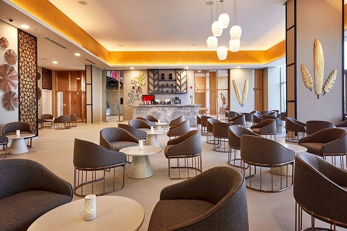 Lobby des Riu Dubai Hotels mit Möbeln und einer Bar.