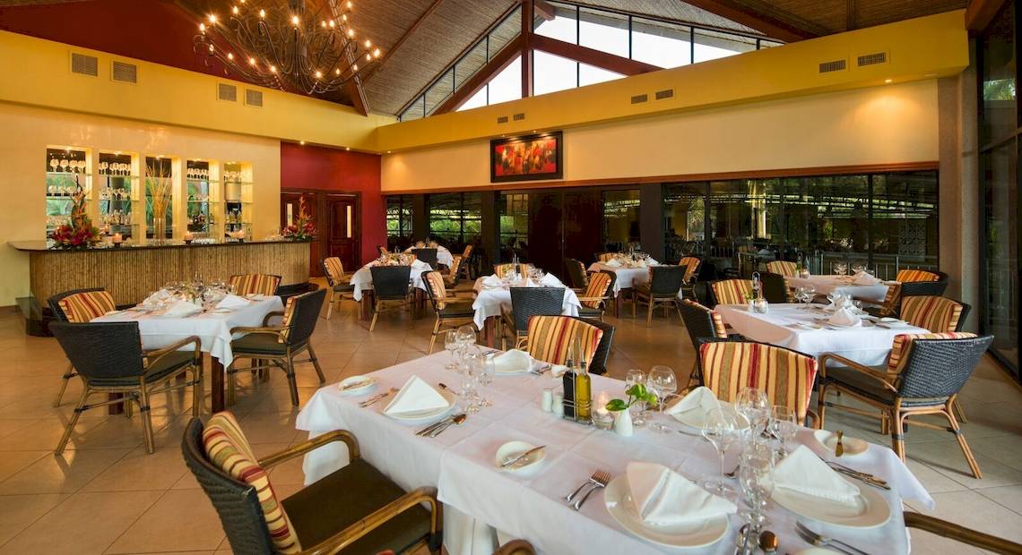 Innenansicht des Restaurants im Occidental Tamarindo Hotel mit eingerichteten Tischen und Stühlen.
