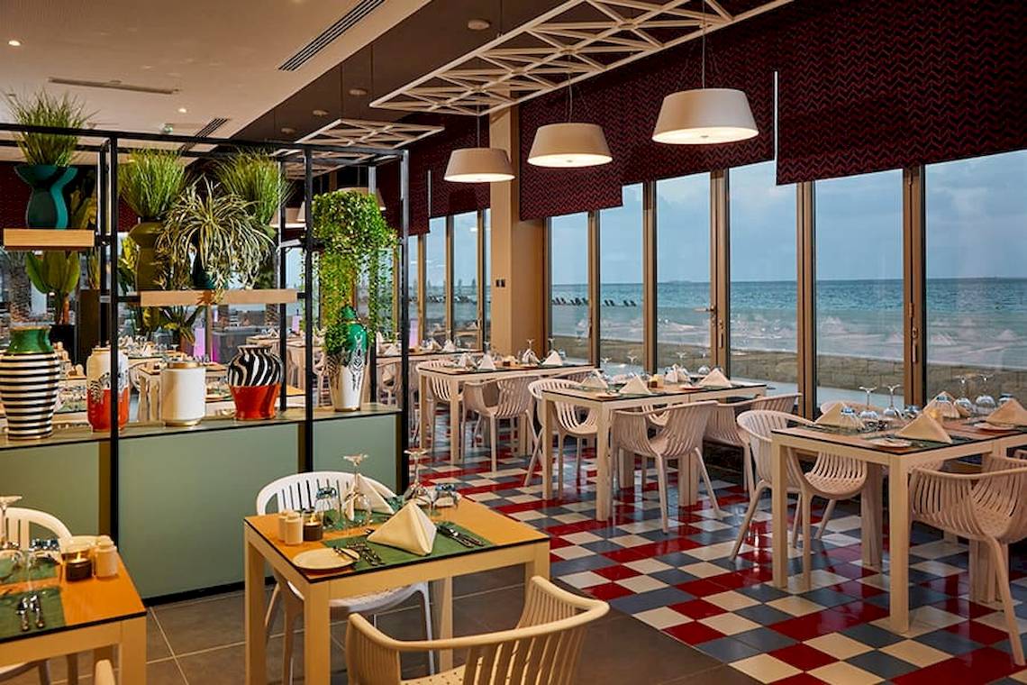 Innenansicht des Restaurants im Riu Dubai Hotel mit Blick auf das Meer.
