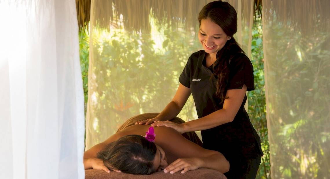 Frau im Occidental Tamarindo Hotel gibt einer weiteren Frau eine Massage.