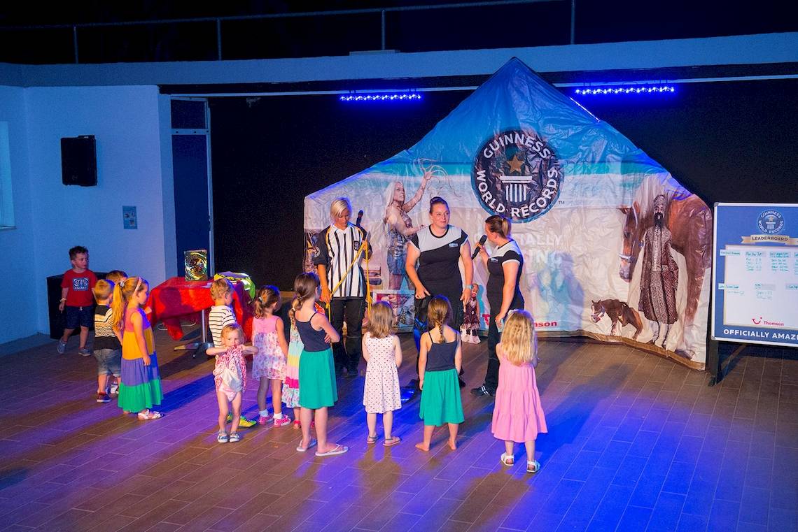 Kindergruppe und Erwachsene vor einer Guinness World Records Zelt mit einer Frau auf einem Pferd.