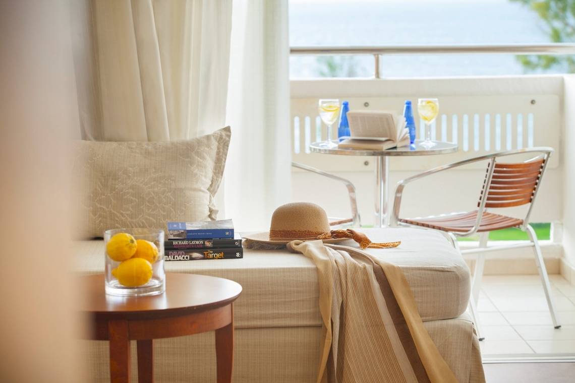 Balkonblick des Louis Kerkyra Blue Hotels mit Möbeln und Büchern.
