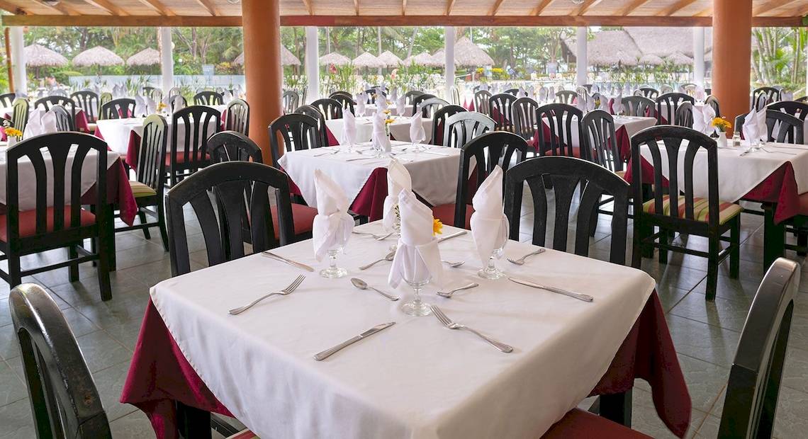 Innenansicht des Restaurants im Occidental Tamarindo Hotel mit gedeckten Tischen und Stühlen.