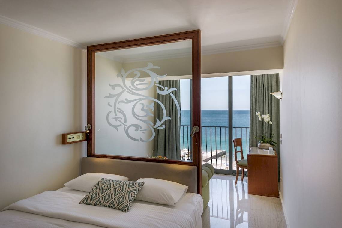 Zimmer im Mitsis La Vita Beach Hotel mit Meerblick, Bett, Balkon und großem Spiegel