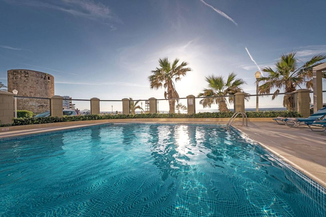 Außenpool des Mitsis La Vita Beach Hotels mit Sonnenliegen und Palmen am Rand