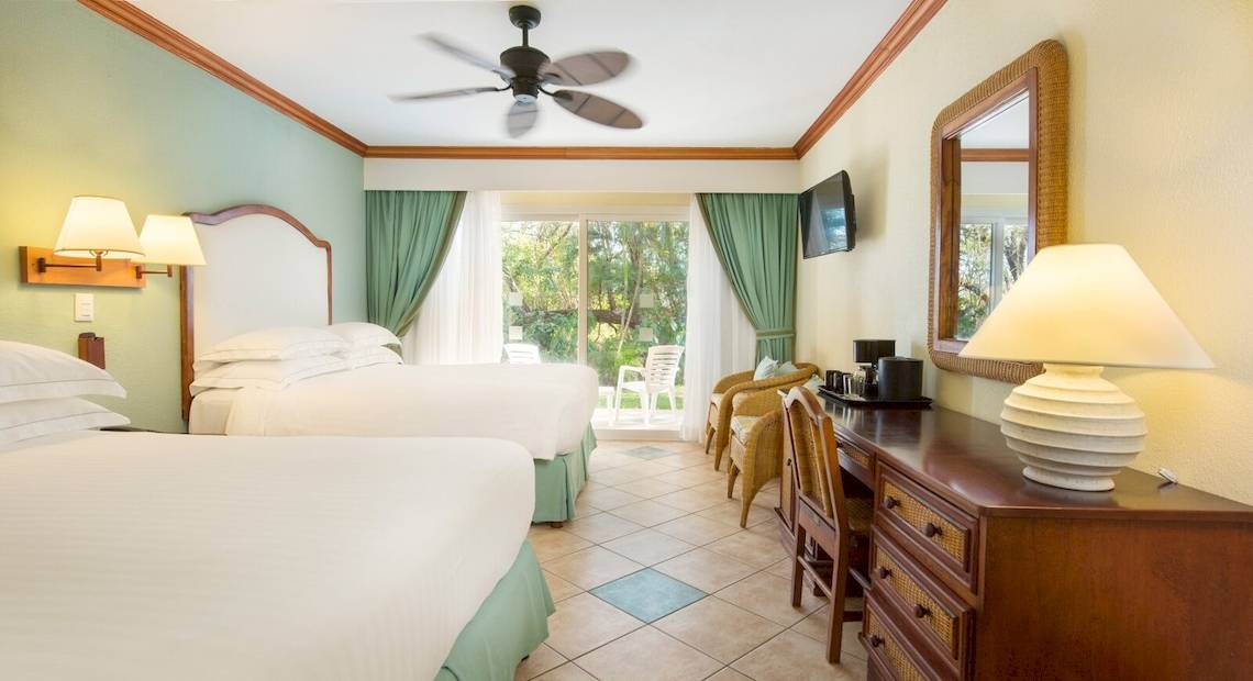 Doppelzimmer im Hotel Occidental Tamarindo mit zwei Betten, Klimaanlage, Fernseher und Terrasse.