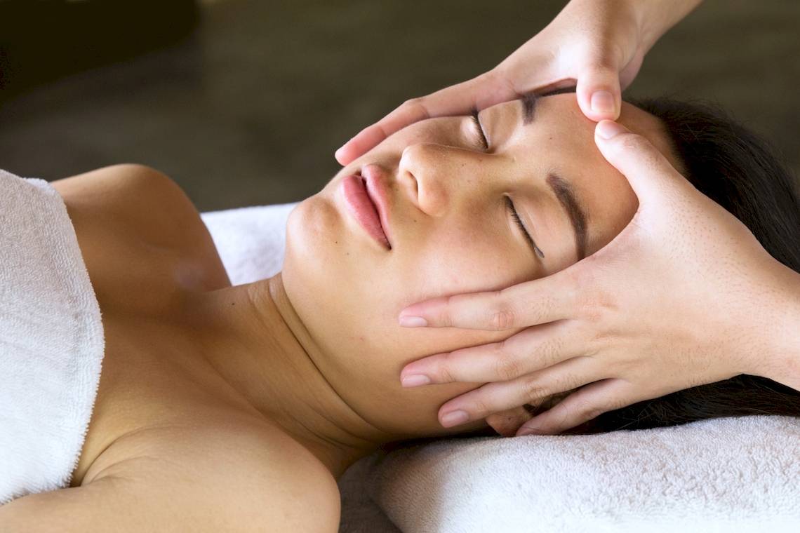 Eine Frau genießt eine Gesichtsmassage im Coco Palm Dhuni Kolhu Hotel.