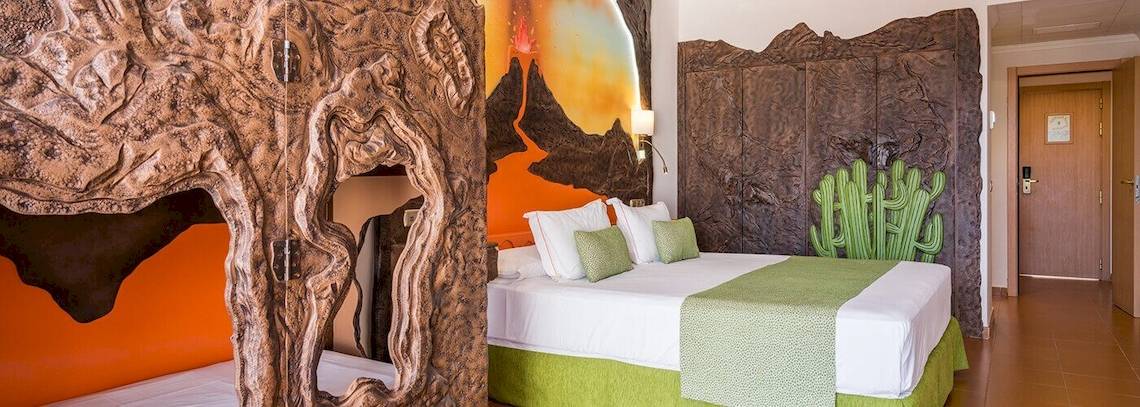 Doppelbettzimmer im Bluesea Costa Bastian Hotel mit vulkanischer Wandmalerei und Kaktusdesign.