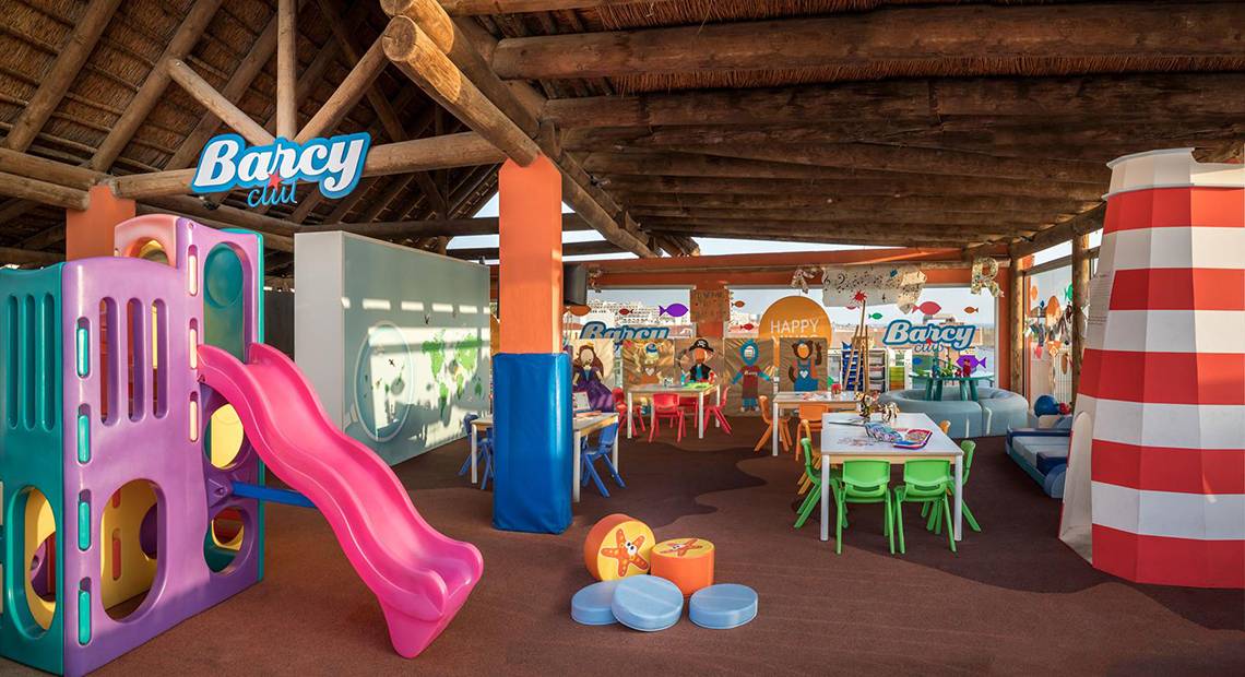 Kinderspielplatz im Barcelo Santiago Hotel mit Rutsche, Tischen und Stühlen.