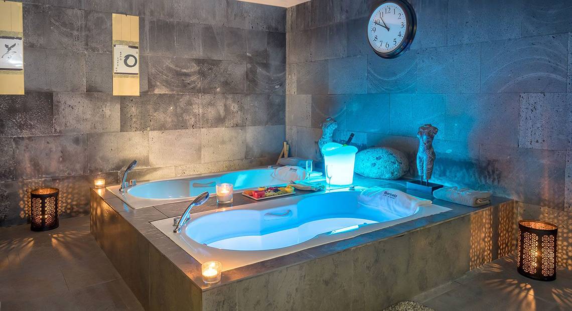 Innenansicht des Jacuzzis im Barcelo Santiago Hotel mit blauen Lichtern und Kerzen.