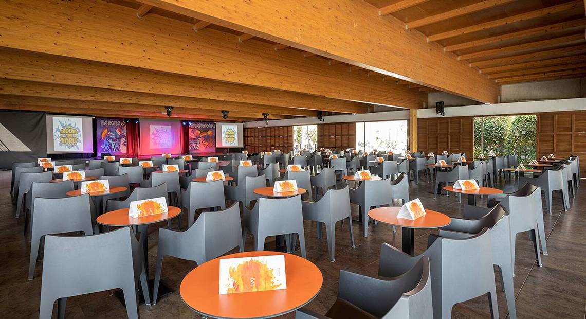 Ein Konferenzraum im Barcelo Santiago mit vielen Tischen und Stühlen, Holzdecken und Projektionsbildschirmen.