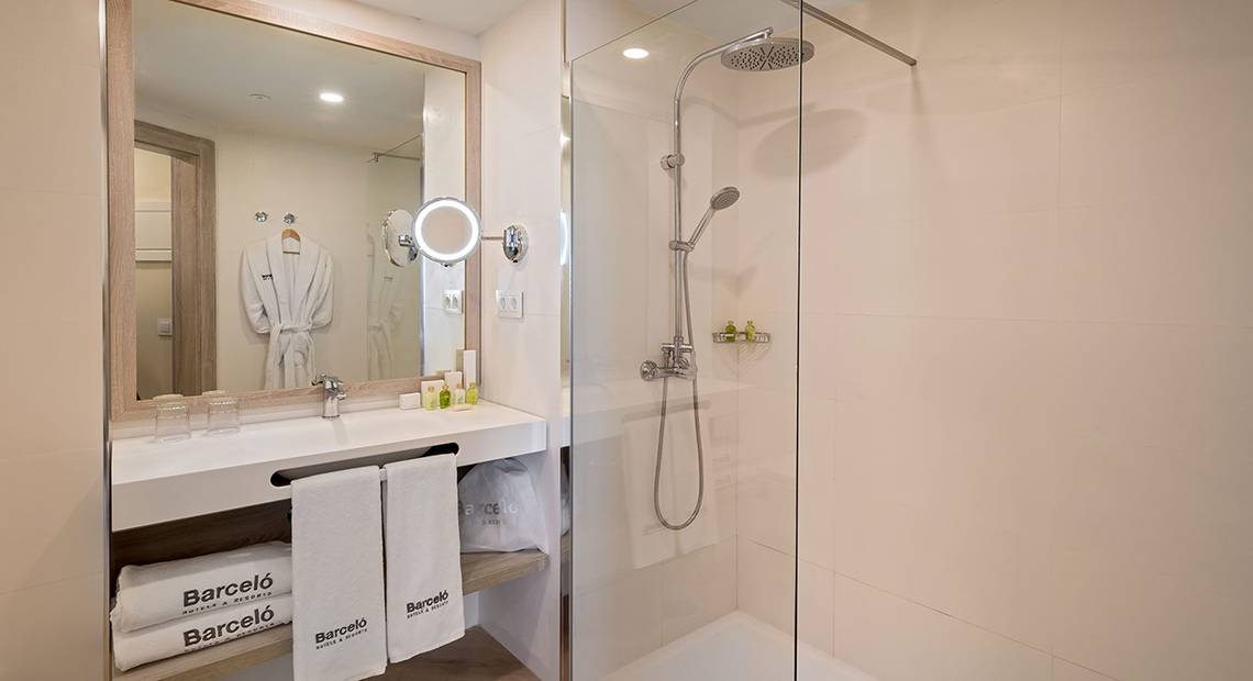 Badezimmer des Barcelo Santiago Hotels mit Dusche, Spiegel und Handtüchern.