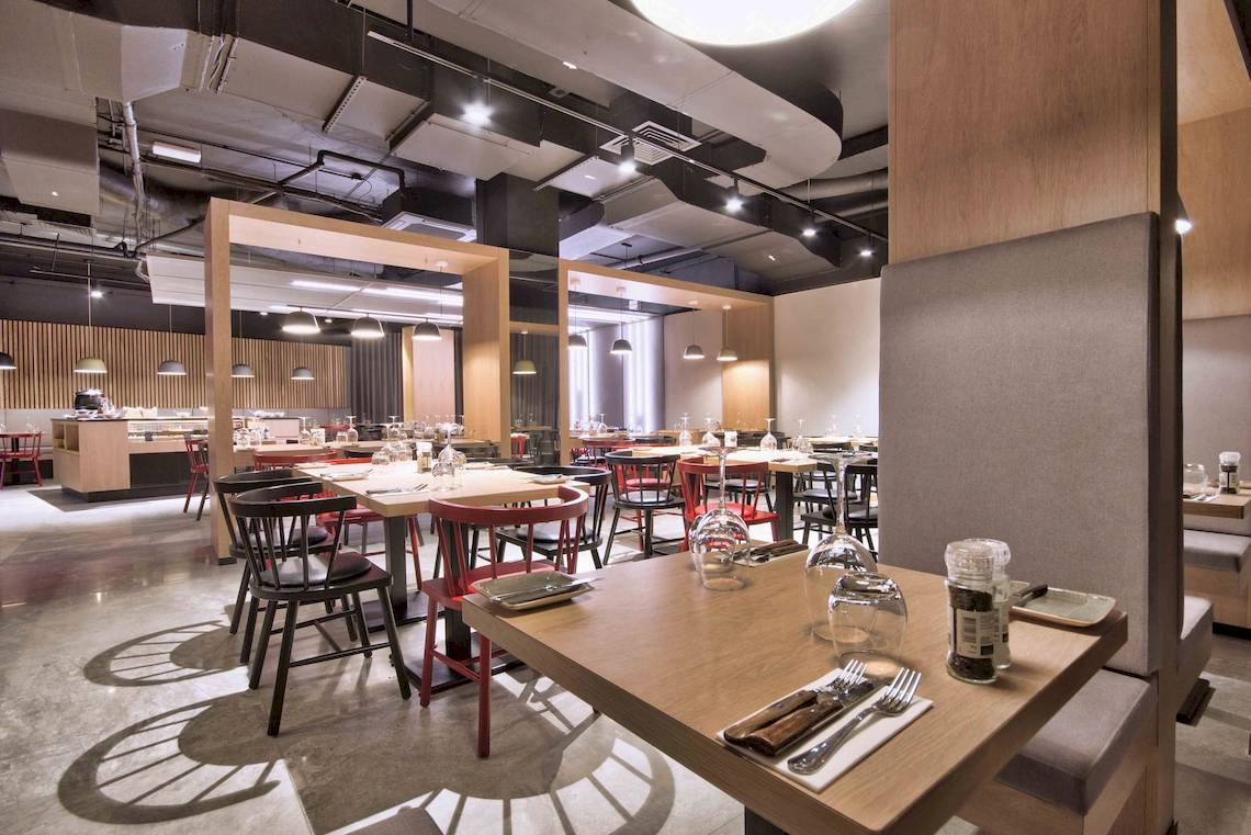 Innenraum des Restaurants im Doubletree by Hilton Malta mit Tischen und Stühlen.