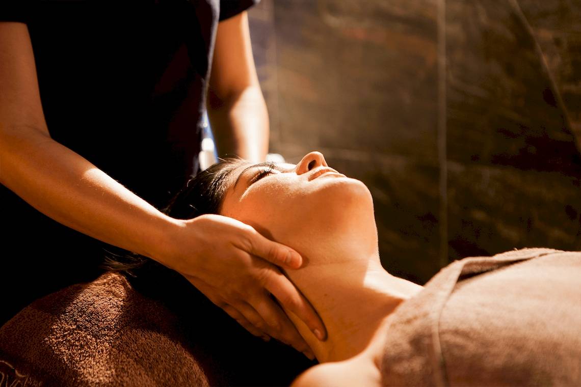 Massage im Doubletree by Hilton Malta, eine Frau genießt eine Gesichtsmassage.