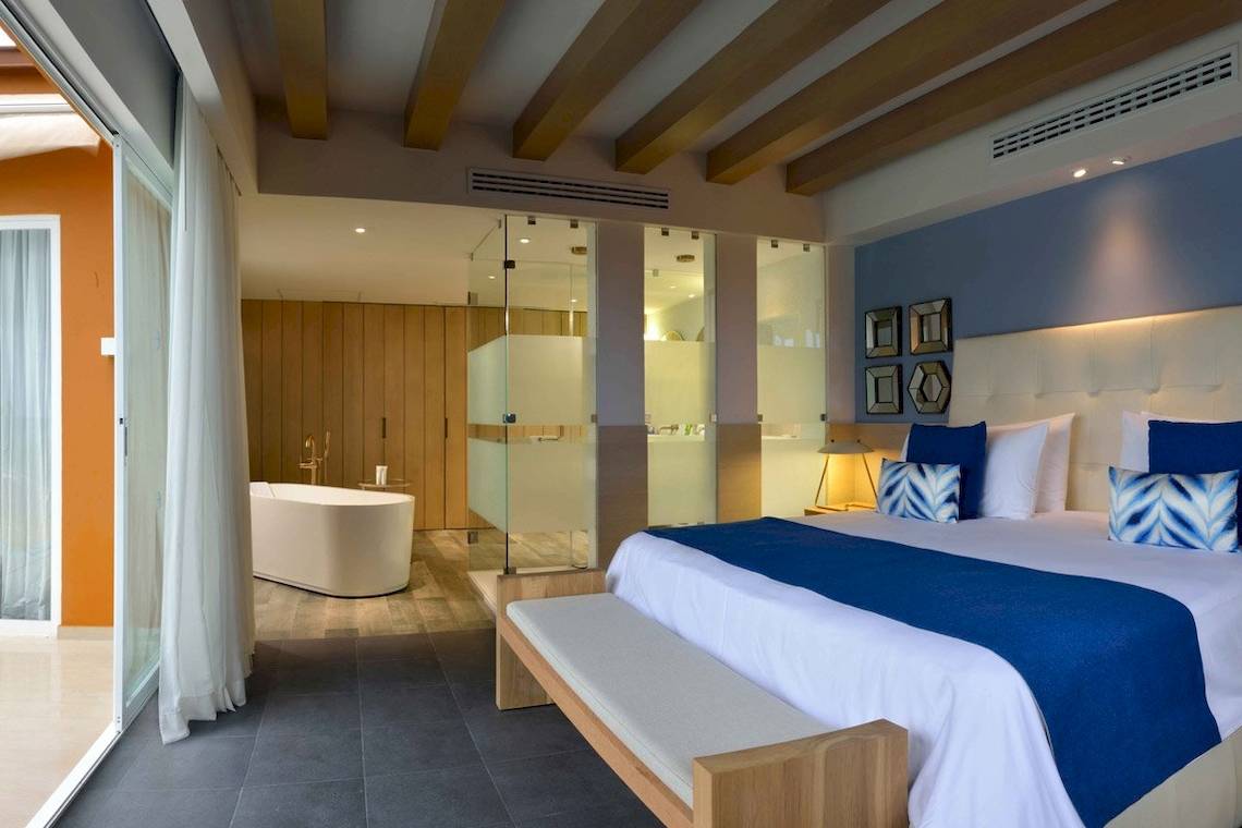 Hotelzimmer im Catalonia Playa Maroma mit Kingsize-Bett, Badezimmer und Badewanne.