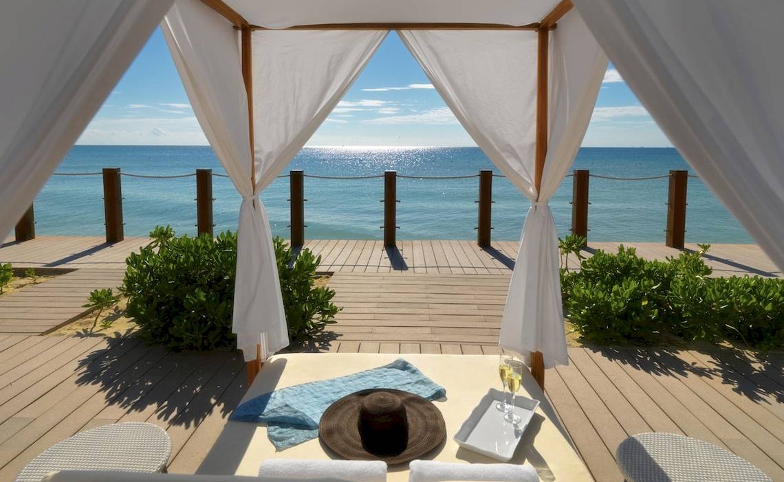 Außenbereich des Ocean Maya Royale Hotels mit Blick auf das Meer von einer Terrasse.