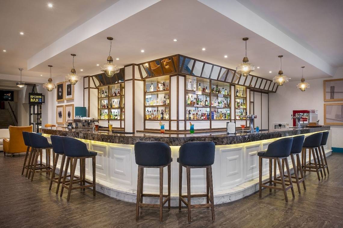 Bar im Ocean Maya Royale Hotel mit Thekenhockern und hängenden Lampen
