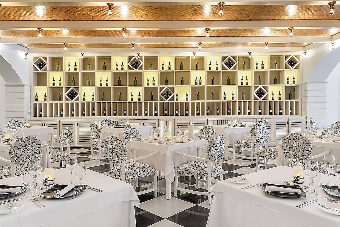 Innenansicht des Ocean Maya Royale Restaurants mit elegant eingerichteten Tischen und Stühlen.