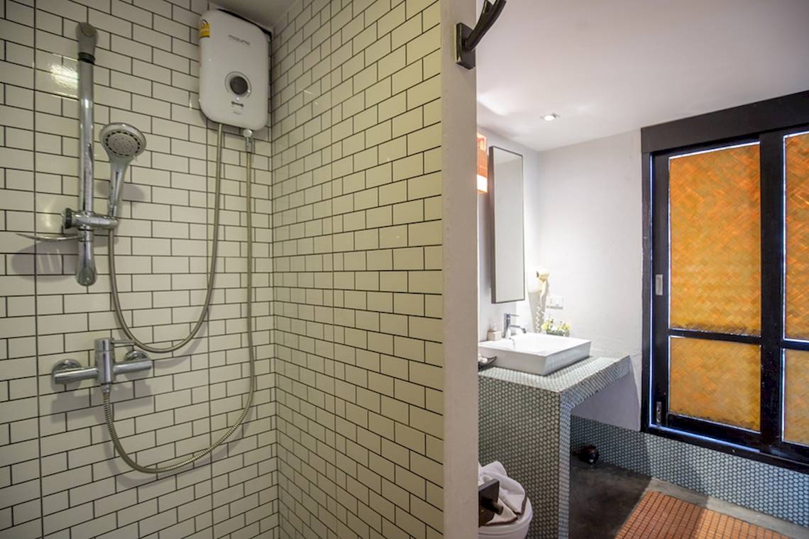 Ein Badezimmer mit einer Dusche, einem Waschbecken und einer Toilette im Punnpreeda Beach Resort.