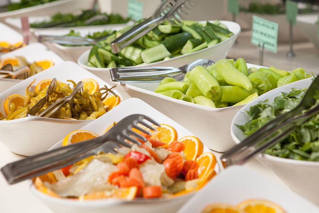 Buffet mit verschiedenen Gemüsesorten und Orangen im Side Aluna Hotel.