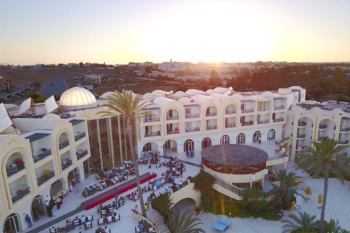 Eden Star Zarzis Hotel Außenansicht bei Sonnenuntergang mit vielen Gästen und Palmen