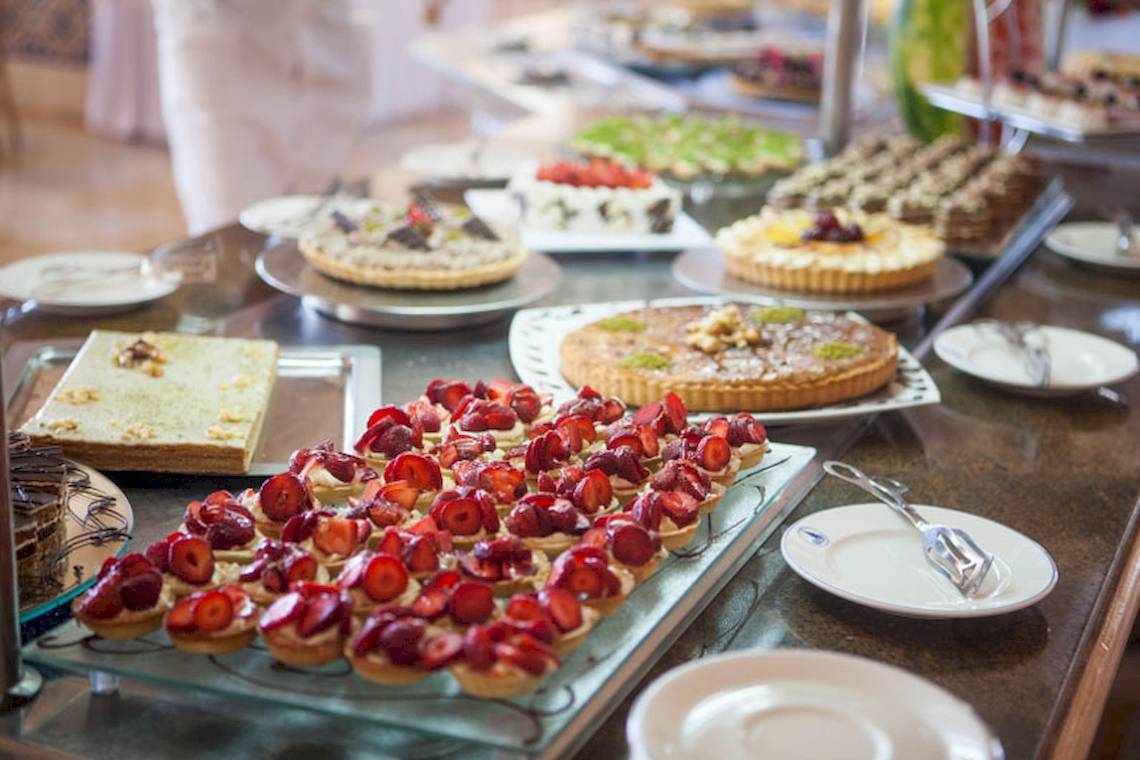 Buffet mit verschiedenen Obstdesserts wie Erdbeeren und Tartes.