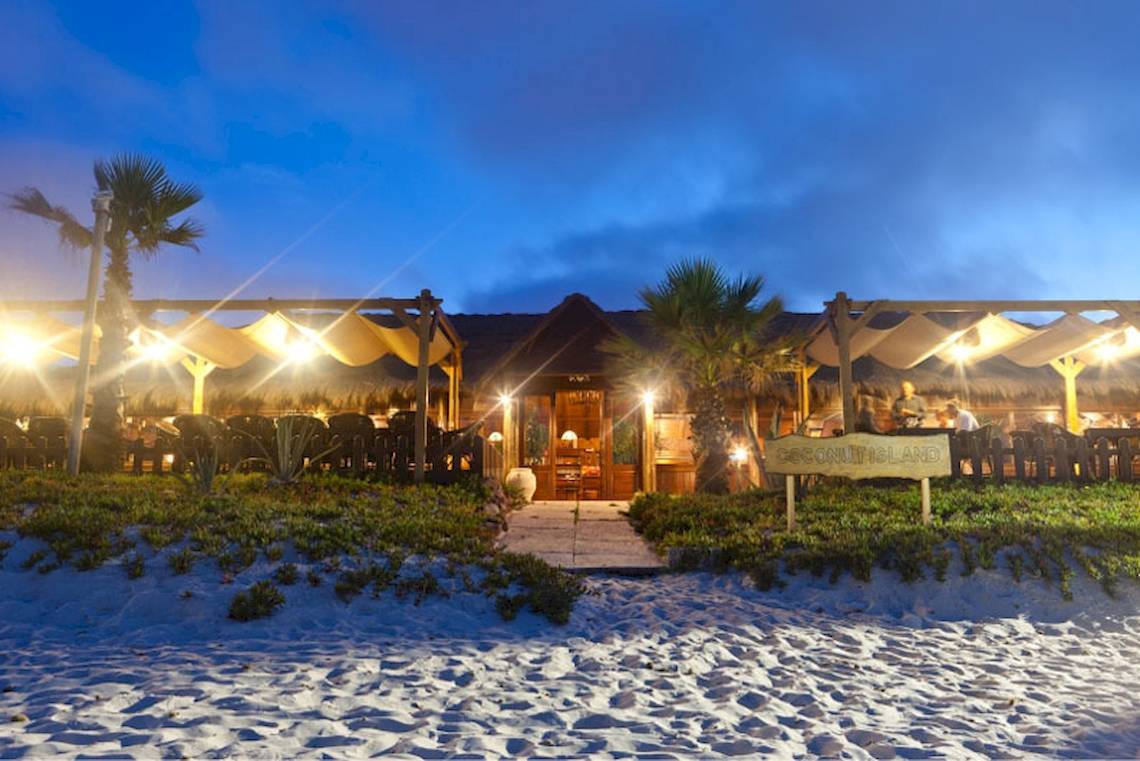 Nachtansicht des El Mouradi Club Kantaoui Hotels mit beleuchtetem Eingang und Restaurantbereich.