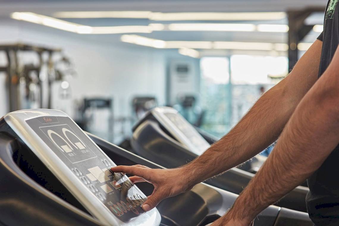 Person benutzt Laufband im Fitnessstudio.