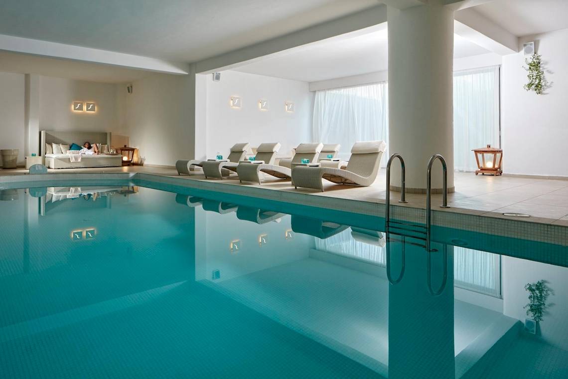 Innenpoolbereich des Aegean Plaza Hotels mit Liegen und Ruhebereichen