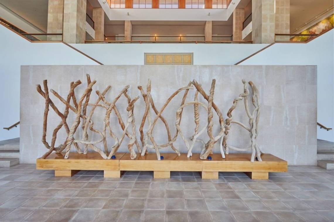 Eine Holzskulptur steht auf einem hölzernen Podest im Innenhof des Hotels.