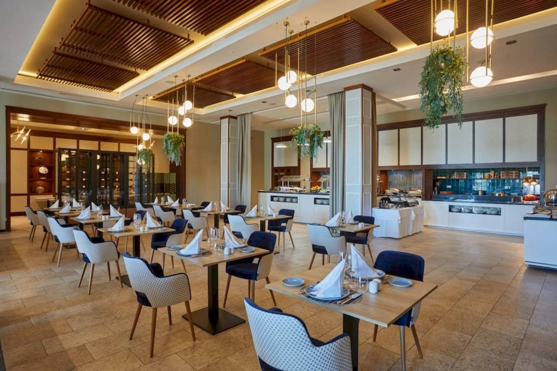 Innenansicht des Restaurants im Secrets Lanzarote Resort & Spa mit gedeckten Tischen und moderner Einrichtung.