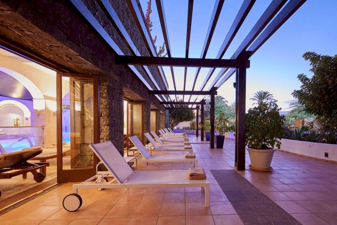 Terrasse mit weißen Liegen im Secrets Lanzarote Resort & Spa