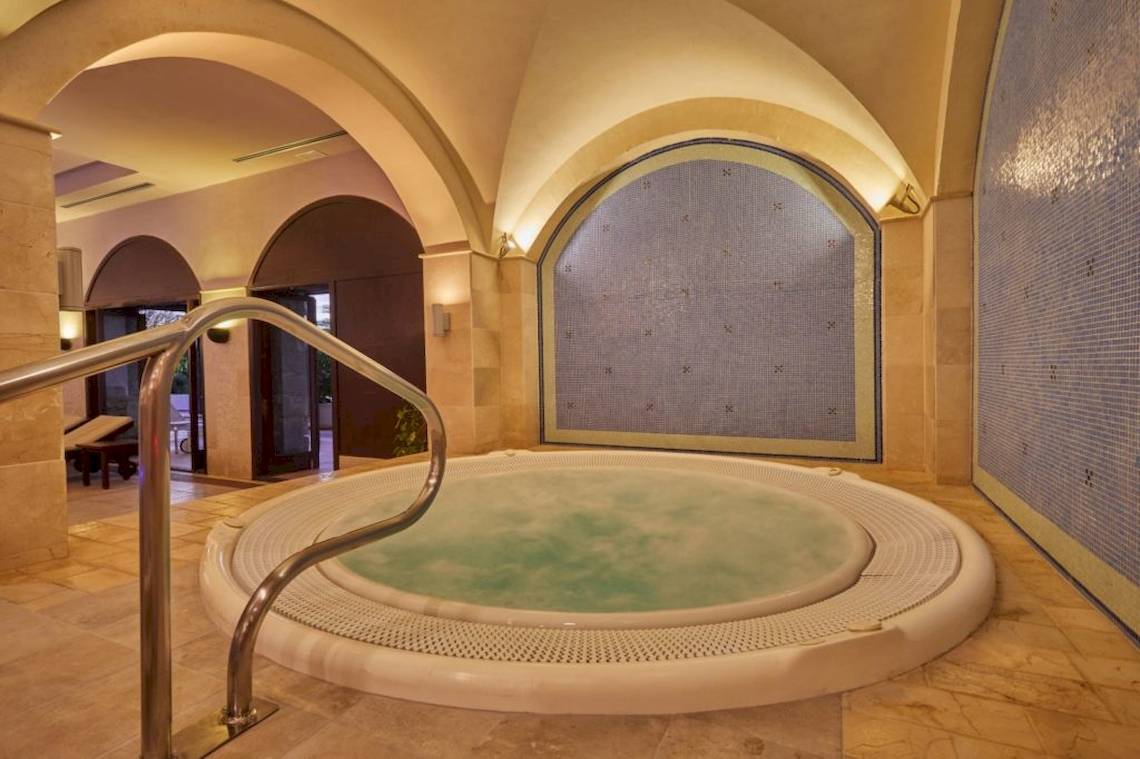 Jacuzzi im Secrets Lanzarote Resort & Spa mit blauen Wandfliesen und Marmorboden.
