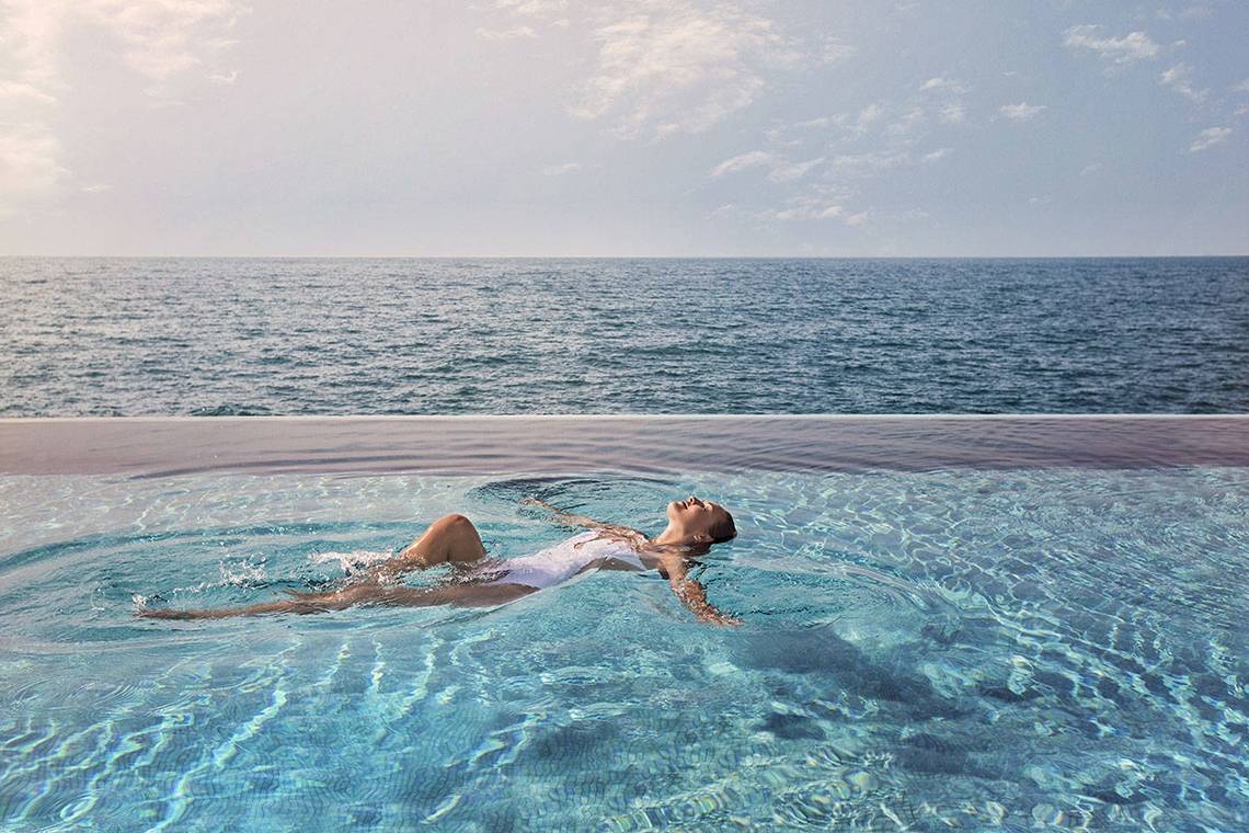 Frau im Burj Al Arab Jumeirah Hotel Pool schwimmen