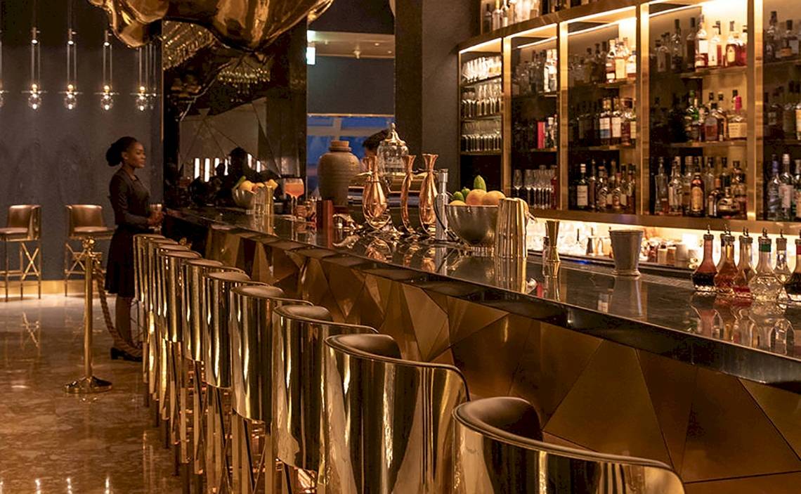 Bar im Burj Al Arab Jumeirah mit goldenen Stühlen und Theke.