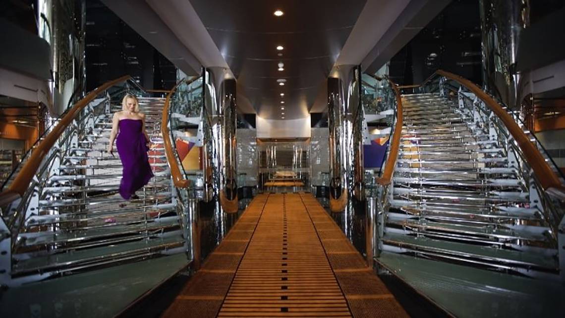 Eine Frau in einem lila Kleid läuft die Treppe eines Hotels hinauf.