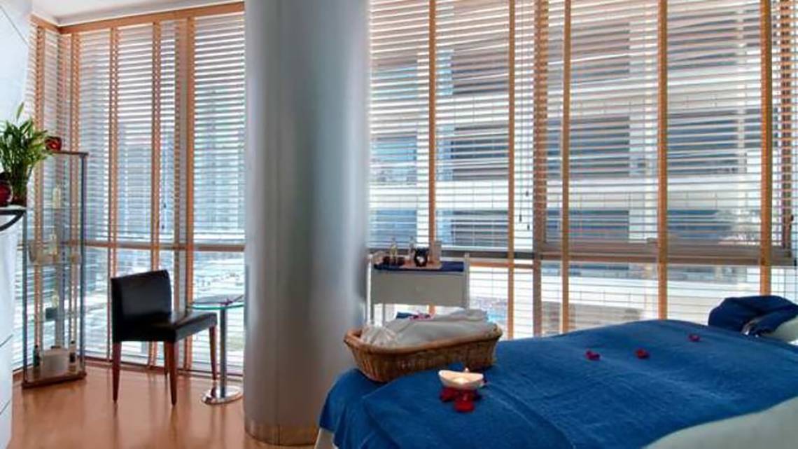 Hotelzimmer im Golden Sands Hotel Creek mit blauem Bett, Kerze, und Blick auf die Stadt.
