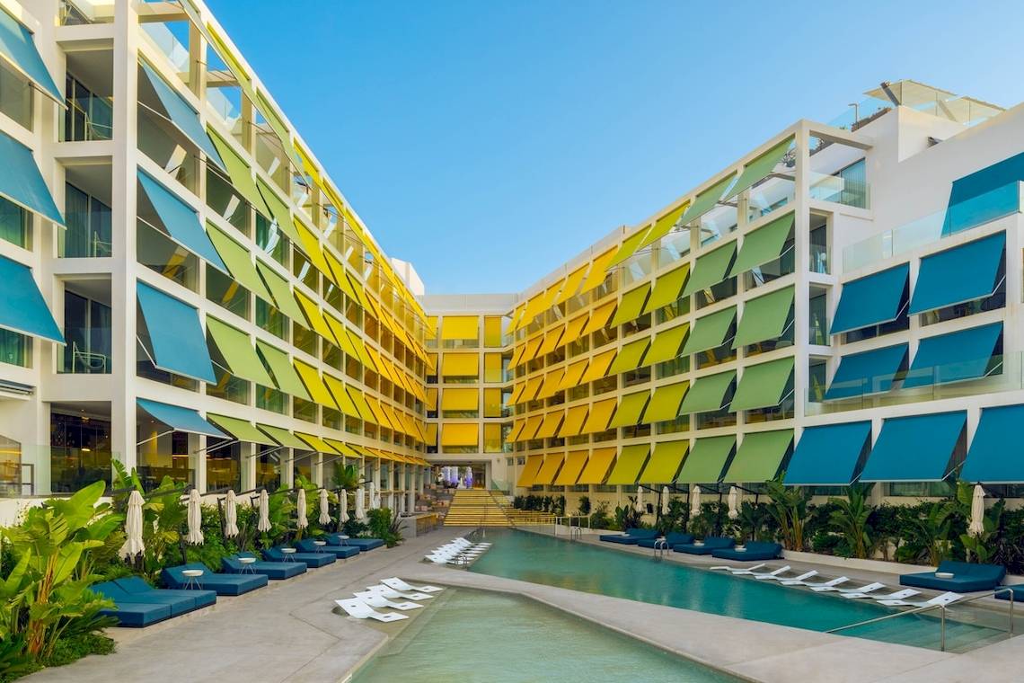 Außenbereich des W Ibiza Hotels mit Swimmingpool und Sonnenliegen