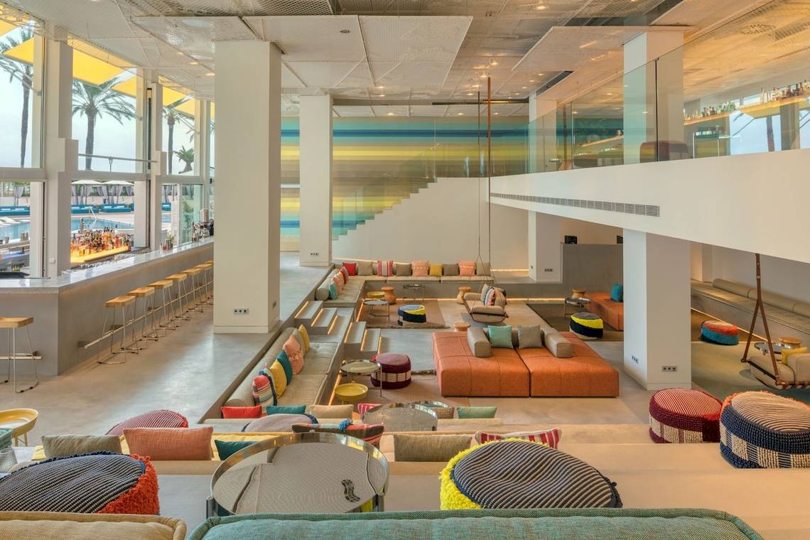 Innenbereich des W Ibiza Hotels mit Bar, bunten Sofas und modernen Möbeln.