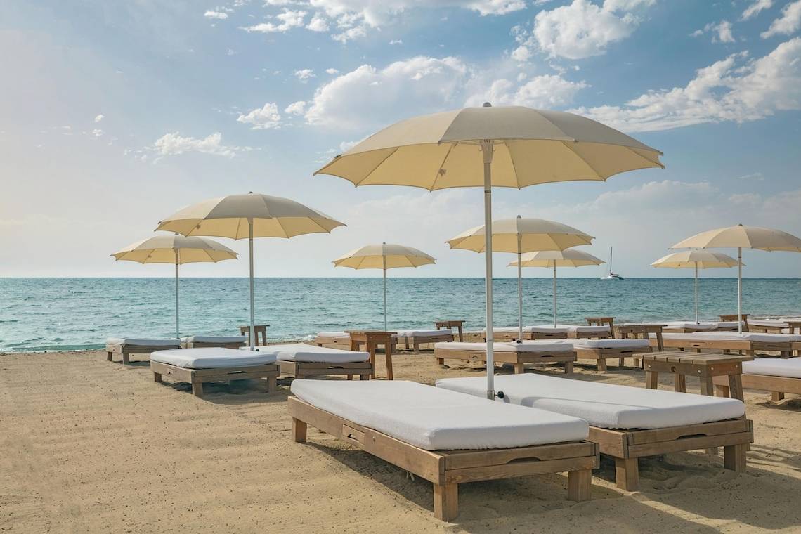 Strand mit Sonnenliegen und Sonnenschirmen im W Ibiza Hotel