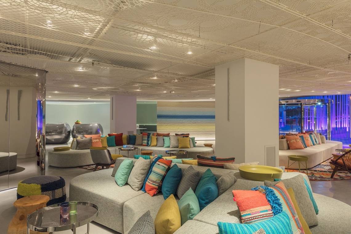 Lobby-Lounge-Bereich des W Ibiza Hotels mit bunten Kissen und modernen Möbeln.
