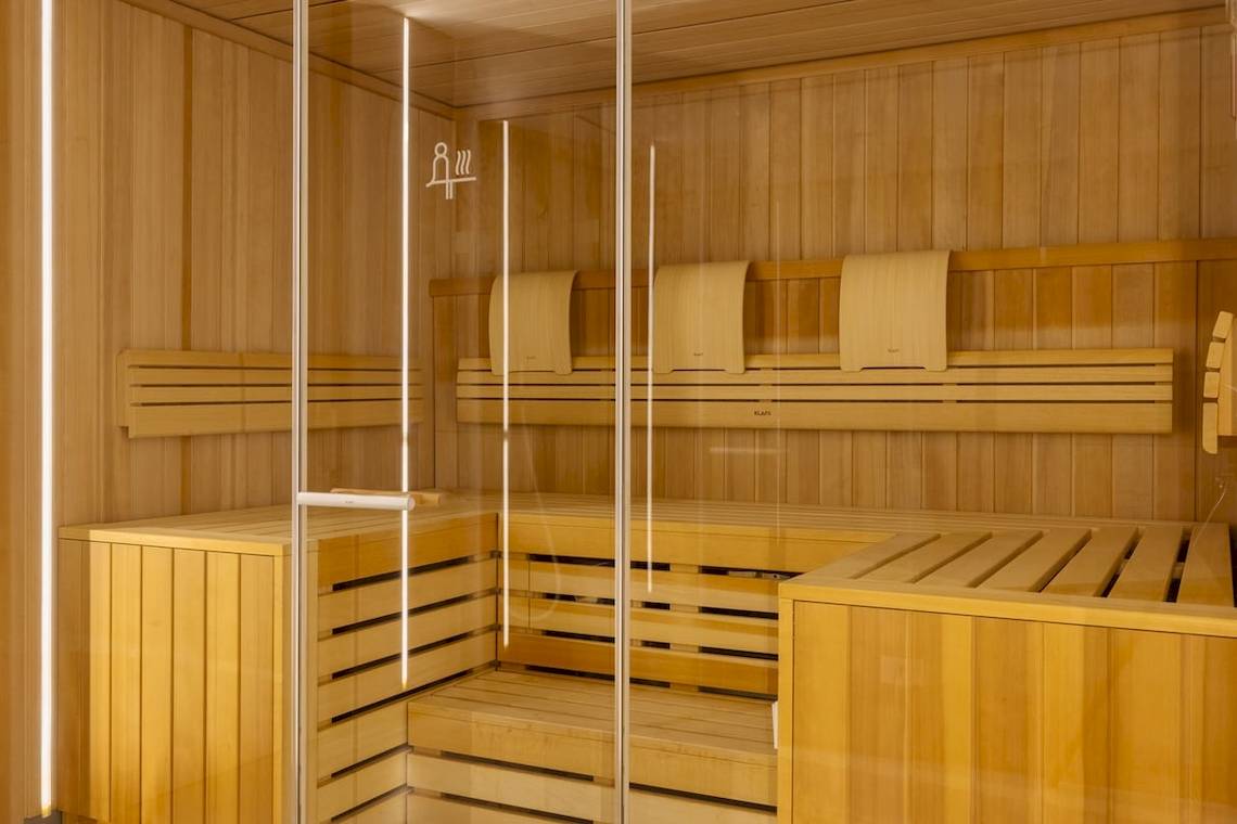 Sauna im W Ibiza Hotel mit Holzbänken und Glaswänden.