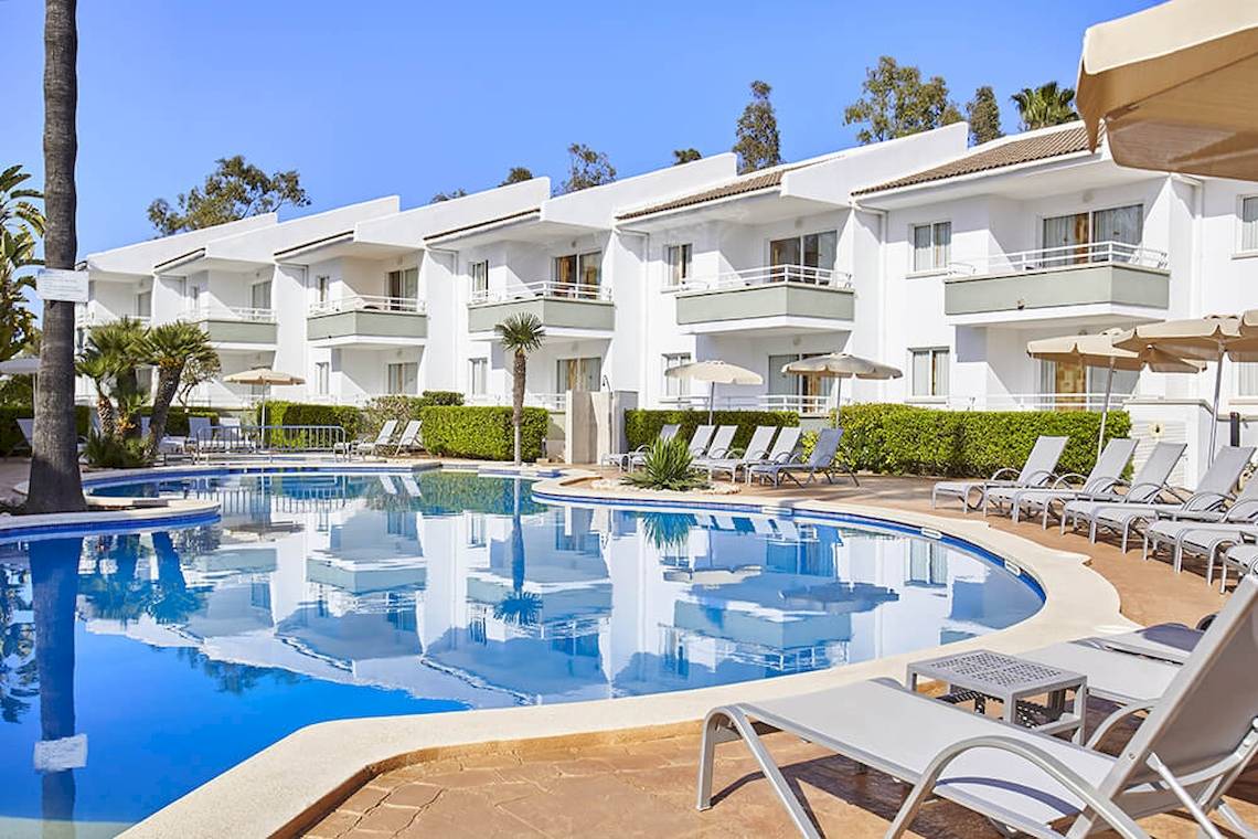 Außenbereich des Universal Aparthotel Elisa mit Swimmingpool und Liegestühlen