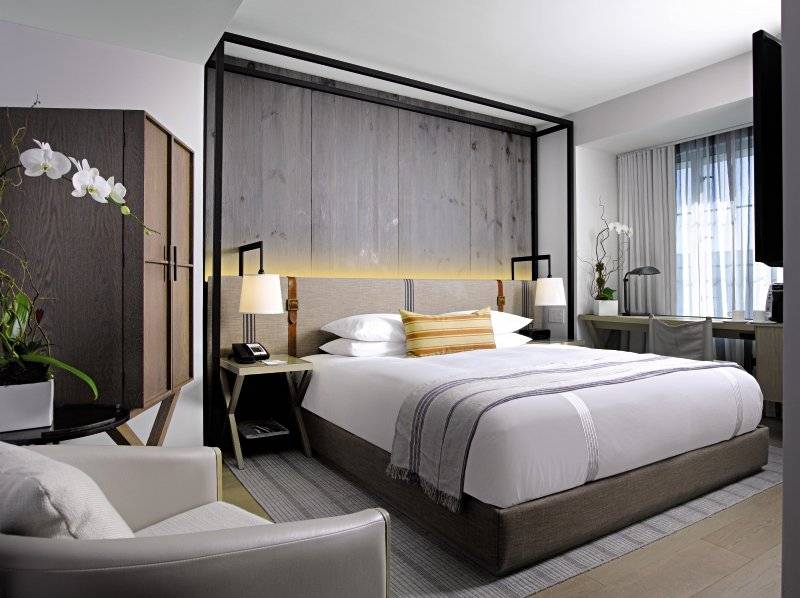 Victor South Beach Hotelzimmer mit Bett, Schreibtisch und Blumendekor.