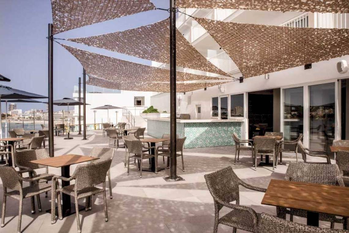 Terrasse des Florida Magaluf Hotels mit Tischen und Stühlen unter Sonnenschirmen.