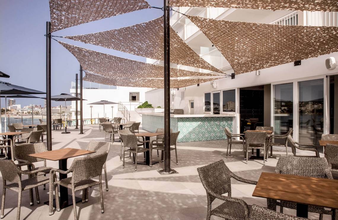 Terrasse des Florida Magaluf Hotels mit Tischen und Stühlen unter Sonnenschirmen.