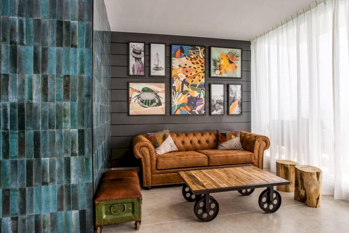 Inneneinrichtung eines Hotels mit einem braunen Sofa, einem Holztisch und dekorativen Wandbildern.