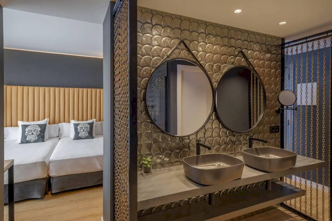 Doppelzimmer im Florida Magaluf Hotel mit angrenzendem Badezimmer, zwei Spiegeln und zwei Waschbecken.
