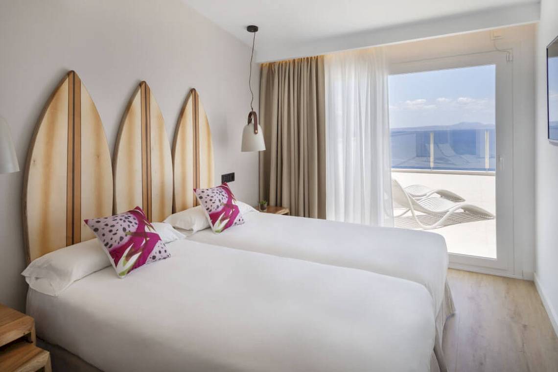Zimmer im Florida Magaluf Hotel mit Blick auf das Meer und Lounge-Stuhl auf der Terrasse.